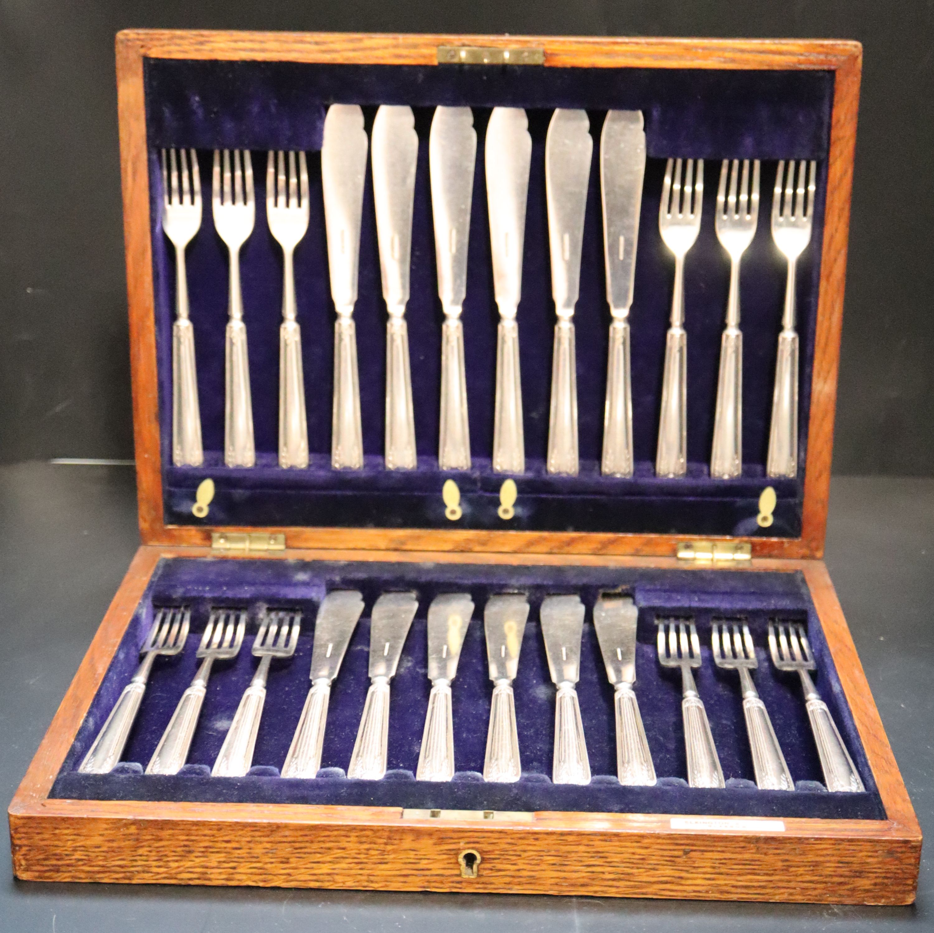 An oak cased set of twelve pairs of Elkington & Co silver plated fish knives and forks,